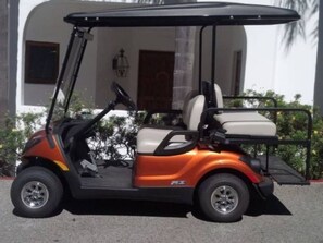 A golf cart parked in front of a building with a door and window. - Cozy 1bd Oceanfront balcony view and golf cart (Avalon)