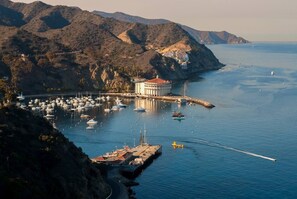 A coastal marina with boats, a pier, and a building with a red roof. - Cozy 1bd Oceanfront balcony view and golf cart (Avalon)
