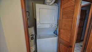 A compact laundry area with a washing machine and dryer stacked vertically.