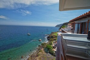 A balcony with a view of the sea and a coastal landscape.