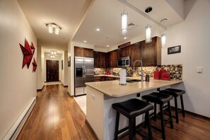 A modern kitchen with a central island, stainless steel appliances, and wooden cabinets.