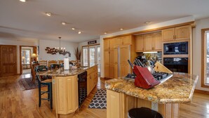 A spacious kitchen with wooden cabinets, a granite countertop, and modern appliances including a microwave and oven.