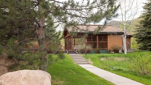 Una cabaña de madera con un sendero de piedra que conduce a una terraza de madera.