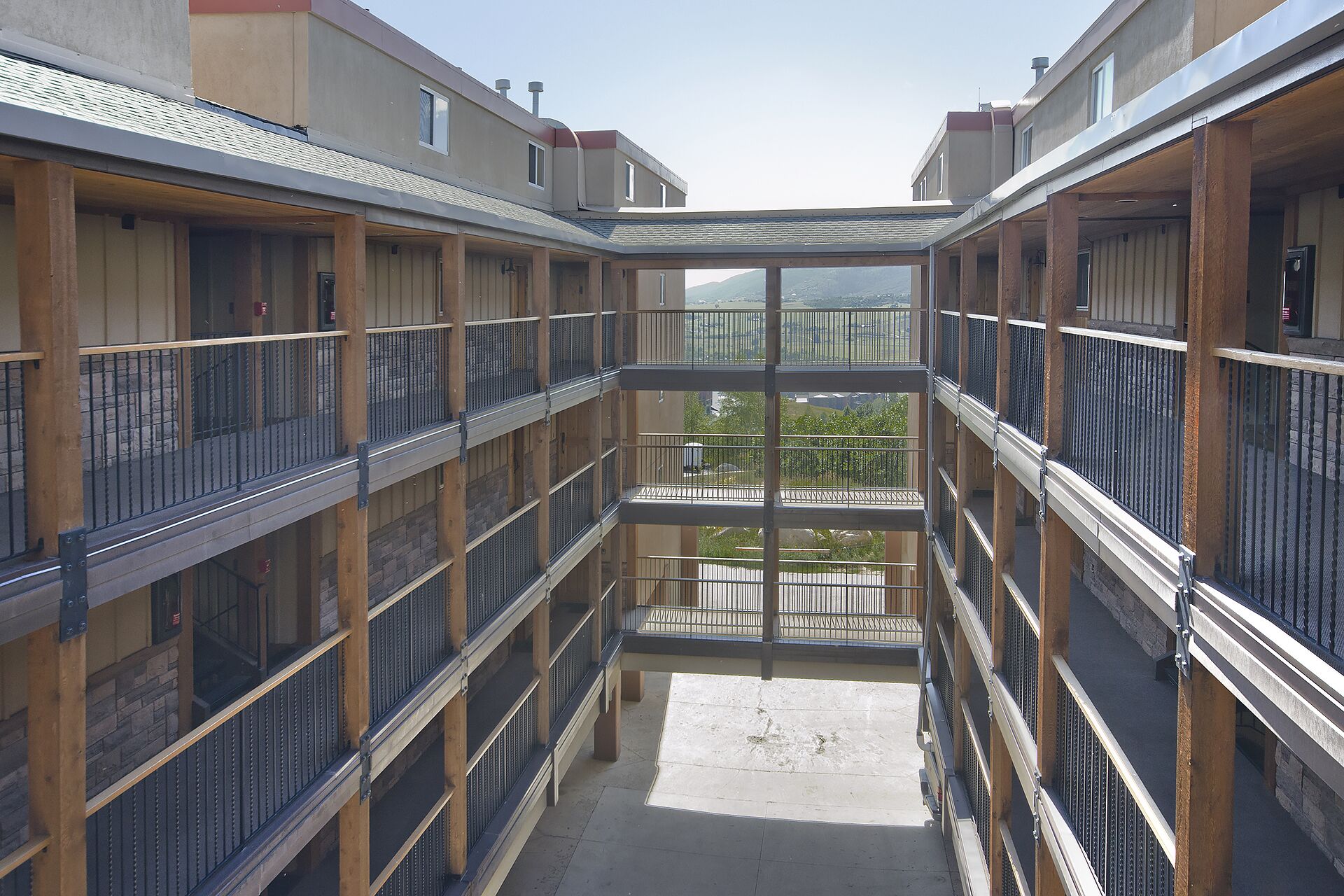 Ein mehrgeschossiges Atrium mit Balkonen, einem offenen Innenhof und Blick auf die Umgebung.