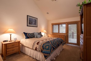Cozy retreat with a large bed, nightstand, and framed picture.