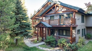 A two-story log cabin with a balcony, surrounded by a forest. - SCK765 | Great Location | Free City Bus | Close to Slopes (Steamboat Springs)