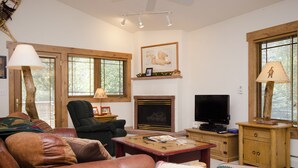 A living room with a fireplace, a television, a sofa, and a chair. - SCK765 | Great Location | Free City Bus | Close to Slopes (Steamboat Springs)