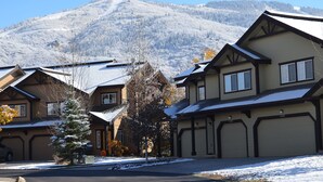 A residential area with houses featuring gabled roofs and a mountain in the background. - V1421 | Private Garage | Hot Tub | Free City Bus | 5 Minutes to Base Area (Steamboat Springs)