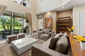 Relax in this stylish living room with a large sofa, coffee table, and potted plant, leading to an outdoor space.