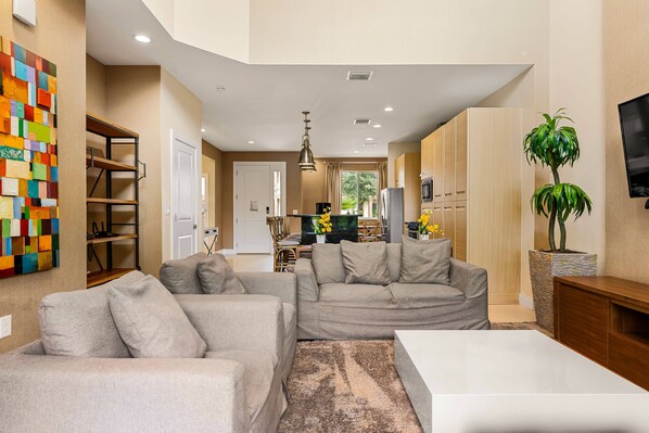Relax in this stylish living room with a large sofa, coffee table, and abstract art piece.