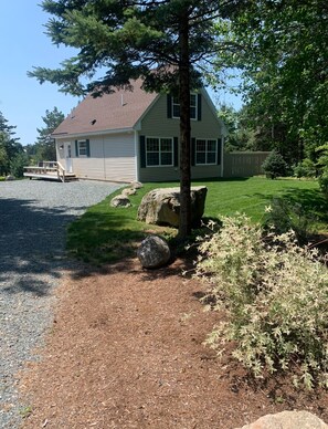 Surrounded by a lush lawn and a tree, this single-story house offers a serene living environment.