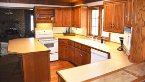 A kitchen with wooden cabinets, a stove, and a dishwasher. - Charming Home In Quiet Location Near Downtown Holland! (Holland)