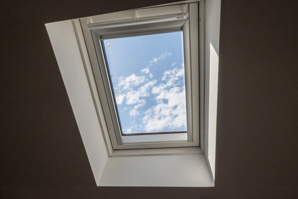 Un tragaluz con vista despejada al cielo y nubes.