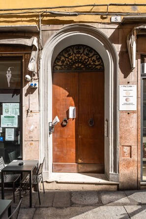 Una porta in legno con un arco in metallo e un cartello sopra.