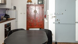 A compact kitchen with a dining area, a microwave, a stove, and a refrigerator.