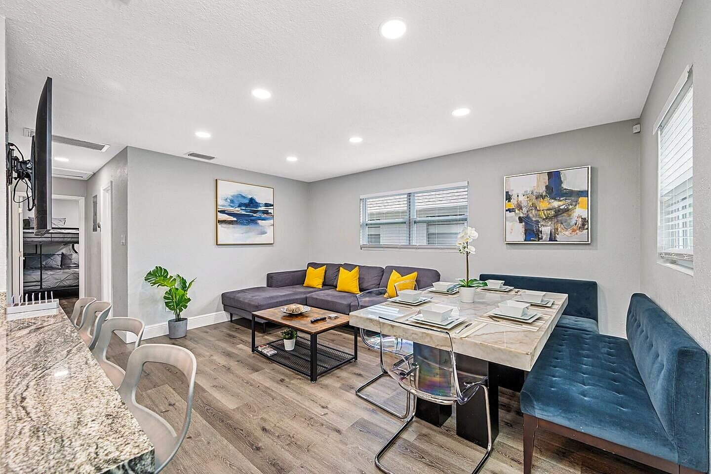A modern living room with a sofa, coffee table, and dining table.