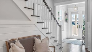 A staircase with a modern design, a bench with cushions, and a view of the outside.