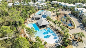 A resort with multiple buildings, a central pool area, and surrounding greenery.