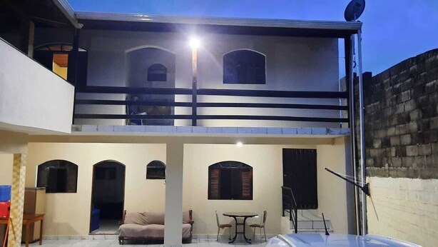 Un bâtiment à deux étages doté d’un balcon, d’une antenne parabolique et d’un mur en briques.