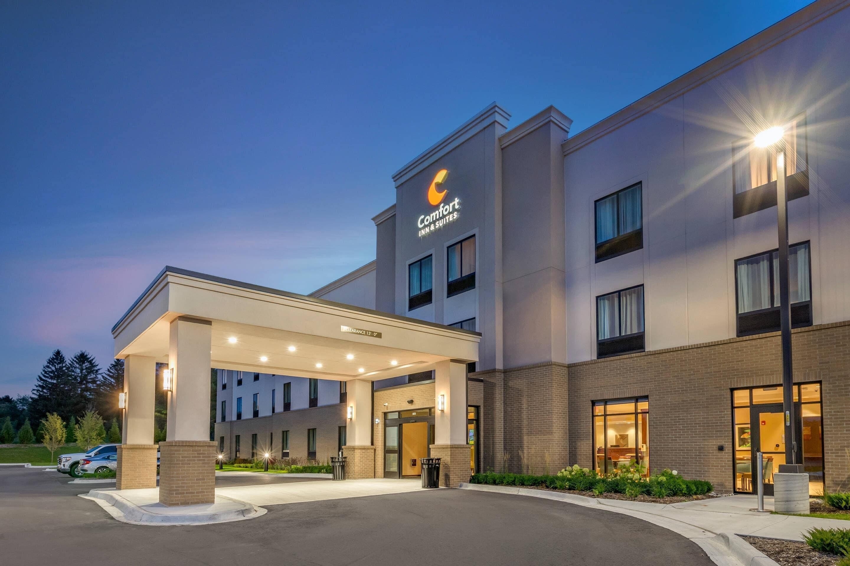 A Comfort Inn & Suites with a covered entrance, multiple windows, and a well-lit facade.
