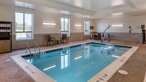 A swimming pool with clear markings, a sunlit room with a view, and a reception area with chairs and a counter. - Comfort Inn & Suites Clarkston Pine Knob Area (Clarkston)