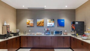A modern kitchen with a microwave, coffee maker, and a refrigerator. There are food items on the counter and a coffee station. - Comfort Inn & Suites Clarkston Pine Knob Area (Clarkston)