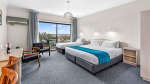 A hotel room with two beds, a dining area with a table and chairs, a TV mounted on the wall, and a balcony with a view. - Comfort Inn The Lakes (Mount Gambier)