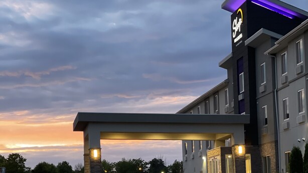 Ett hotell med modern design, kännetecknat av en framträdande skylt och en överbyggd entré.