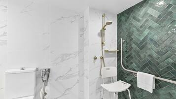 A bathroom with a shower, toilet, and a towel rack.