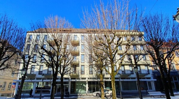 Un edificio de varios pisos con fachada plana, ventanas amplias y acceso en planta baja.