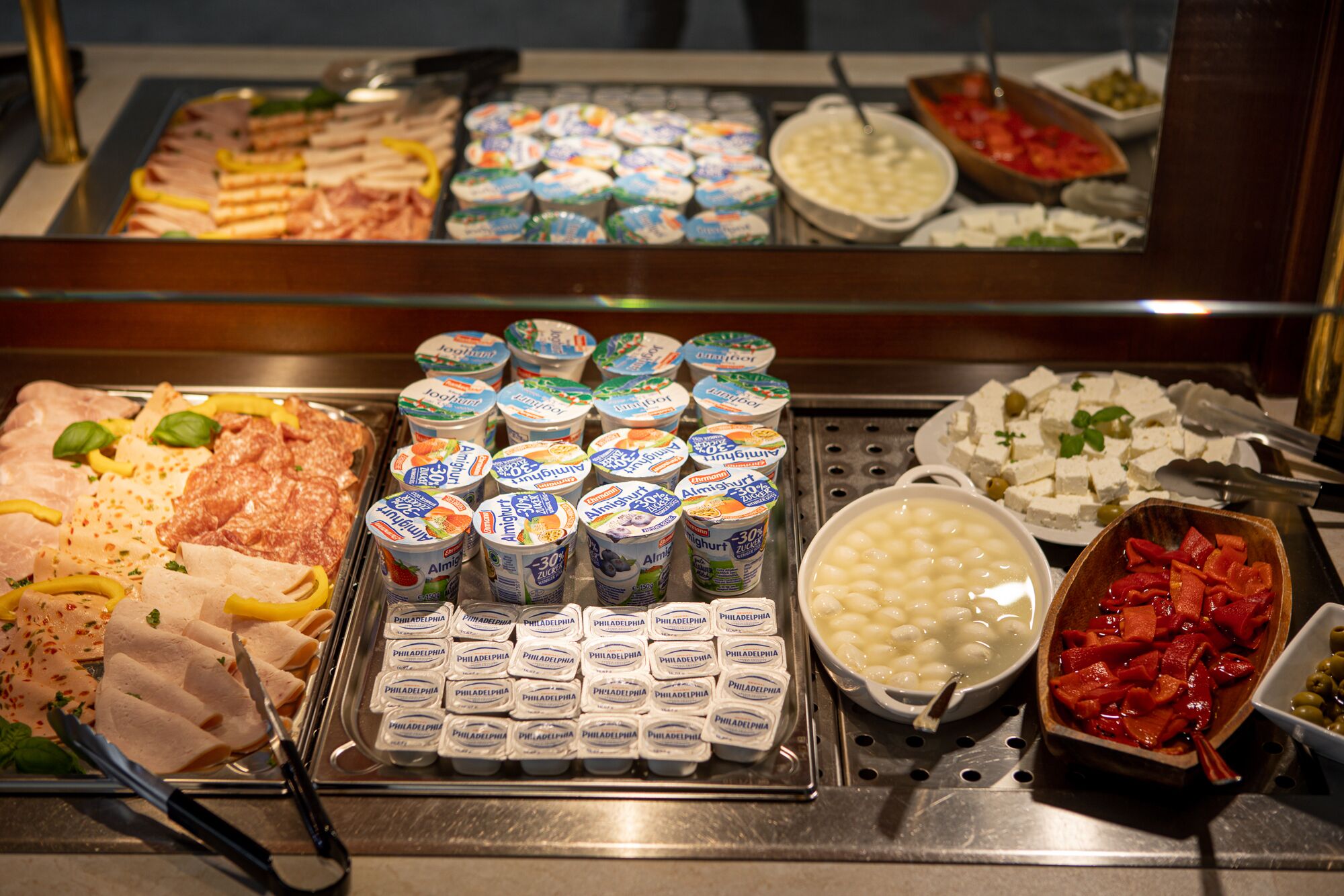 Ein Buffet mit verschiedenen Speisen, darunter Fleisch, Käse und Dips.