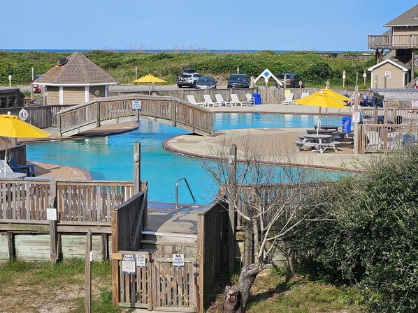 A wooden deck with a pool, a wooden bridge, and a sign indicating private property for owners and guests only.