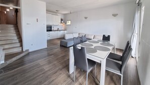 A modern apartment with a dining area, kitchen, and living space. - Apartment Maya 1 (Marušici)