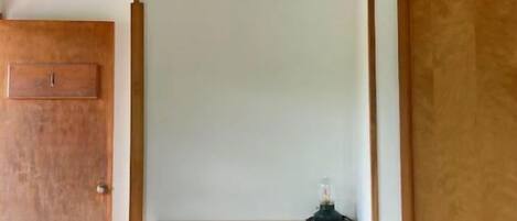 Une pièce avec un plafond en bois, un mur blanc et une porte en bois.