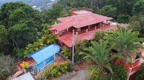 Surrounded by lush greenery, this two-story building offers a balcony and staircase leading to the entrance.