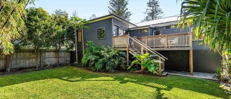 A two-story house with a deck and a fenced backyard.
