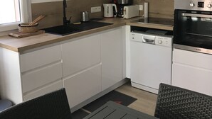 A modern kitchen with white cabinets, a microwave, a coffee maker, and a dishwasher. - Dans Domaine Privé et Sécurisé Appt Type 2 Avec 3 Piscines , 2 Tennis (Cogolin)