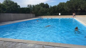 A swimming pool with clear blue water, surrounded by a stone deck and trees in the background. - Dans Domaine Privé et Sécurisé Appt Type 2 Avec 3 Piscines , 2 Tennis (Cogolin)