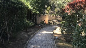 A gravel pathway in a garden area with various plants and trees. - Dans Domaine Privé et Sécurisé Appt Type 2 Avec 3 Piscines , 2 Tennis (Cogolin)