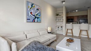 Un saló modern amb un sofà beix, una taula de centre i una pintura abstracta contemporània.