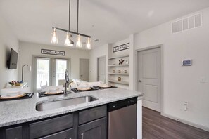 Enjoy cooking in this well-equipped kitchen with a dishwasher, double sink, and pendant lighting.