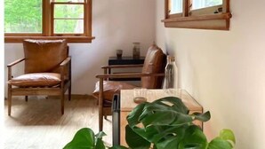 A cozy room with wooden beams, a wooden chair, a dining table, and a large plant.