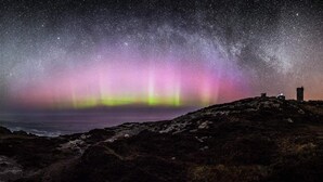 A night sky with the aurora borealis over a rocky landscape with a small building. - SolasTobann Room 1 En-suite Malin Head  (Malin Head)