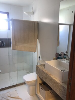 Een bad/douchecombinatie, handdoeken