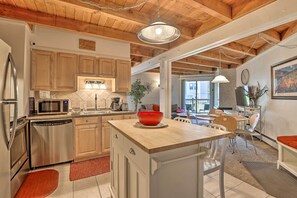 A modern kitchen with wooden cabinets, stainless steel appliances, and a central island. - Ski Shuttle & Pool: Modern Silverthorne Condo! (Silverthorne)
