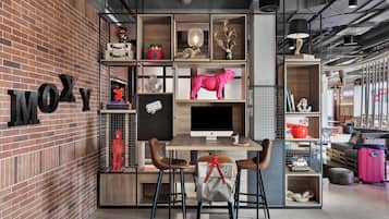 Un espacio de trabajo moderno con pared de ladrillo, un escritorio, dos sillas y varios objetos decorativos.