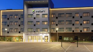 Un moderno edificio de hotel con un llamativo letrero 'element by Westin', varias ventanas y un estacionamiento.