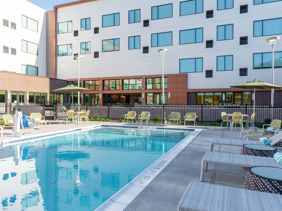 Una piscina al aire libre, sillones reclinables de piscina