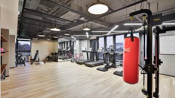 A gym with treadmills, stationary bikes, and a punching bag.
