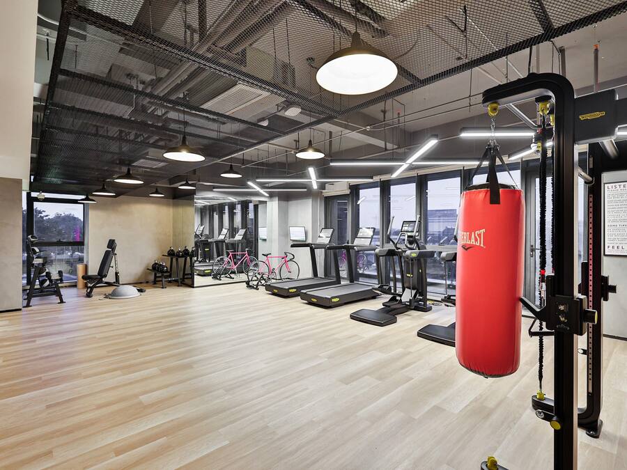 A gym with treadmills, stationary bikes, and a punching bag.